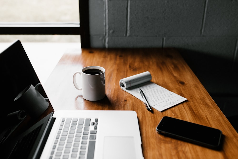 Notebook, cup, and laptop arranged for a mindful resource pause